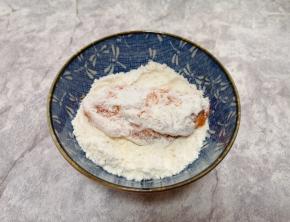 先将腌好的鸡翅放入玉米淀粉里面，表面粘上一层玉米淀粉。