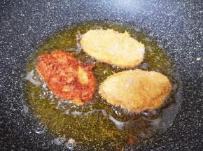 锅内倒入多一点的食用油烧至七成热，放入鸡翅中小火炸制，中间多次翻动，炸至金黄色捞出。