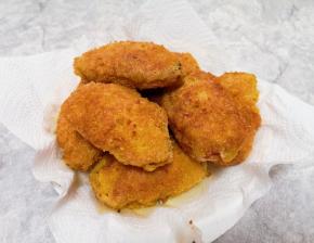 盘子里铺上厨房用纸，放上炸好的鸡翅，吸一下多余的油分。