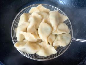 下水煮饺子，煮好的饺子用笊篱捞出。