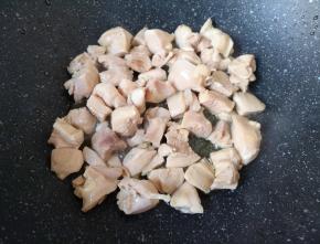 炒锅内倒入适量的食用油烧热，下入鸡腿肉翻炒至变色。