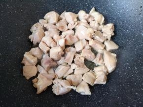 炒锅内倒入适量的食用油烧热，下入鸡腿肉翻炒至变色。