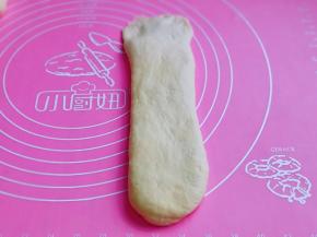 取一块松弛好的面团，再次擀长舌状，上面的尾部薄一点，利于收口处粘合。
