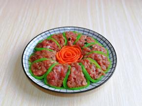 切薄片的胡萝卜再从中间一片切成两片，摆出花开富贵的花朵就可以～