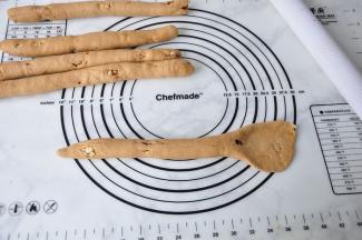 将面团搓长到40厘米左右，右端用擀面杖压扁。