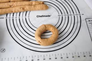 将面团圈起来将另一端放入压扁的面团上，多放进去一些，用压扁部分的面团包好并捏紧收口。