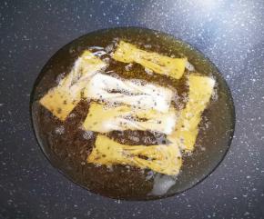 锅内倒多一些调和油烧至7成热，下入做好的麻叶。