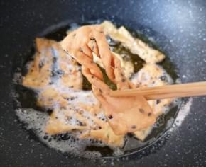 一面变色以后翻面炸另一面，两面都炸至金黄色就可以捞出来了。