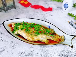 取出蒸好的鱼，淋上蒸鱼豉油，生抽，再淋上热油(油烧热）最后撒上葱花，切好的红辣椒。