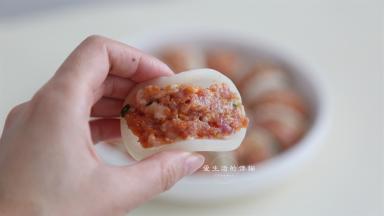 取一块萝卜片，夹入适量的肉馅，用手抹平整，蒸出来会很光滑好看。