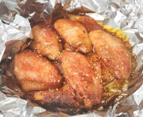 5 烤盘上铺上一层锡纸，码上腌好的鸡翅，连同腌料一起放入。把烤盘放在空气炸锅的高烤架上