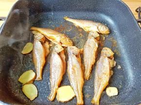 
不粘锅烧热倒油，下姜片大蒜，放入小梅鱼中火煎。