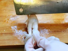 用刀背在中间位置砍一刀，但不要完全断开，骨头断开，皮肉相连就可以。