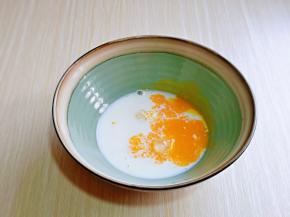 首先做蛋黄糊，蛋黄打散，加入纯牛奶，再加入20克绵白糖，用手动打蛋器充分打至融合。