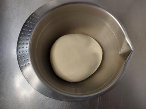 简单收拢成一个光滑且不粘手的面团，放入盆内，保鲜膜密封进行一次发酵。