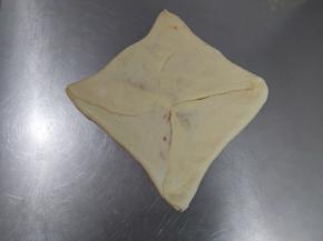 把面团的四个角往里折，轻轻拍压挤出气泡，捏紧收口，压扁。