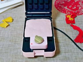 三明治机器链接电源，将定时器旋转到2分钟处预热，预热好后模具上刷少许食用油，再盛入面糊，模具8分满就可以。(如果掌握不好，可以把面糊装入裱花袋中，再挤入模具中，这样比较方便)