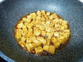 转中小火煮，直到豆腐基本上吸干红烧汁。