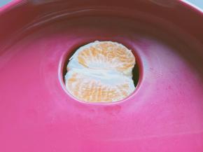 把橘子放入原汁机里面。