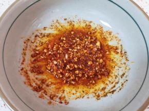 炒锅内倒适量的食用油烧热，浇在蒜末辣椒粉上面，搅拌均匀。