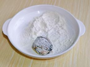 塞好肉馅的茄子，裹上面粉，再轻轻抖掉多余的面粉。