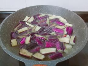 锅里放油、油温五成热下茄子油炸。