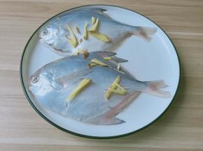 生姜切片或丝、葱切段，将鱼摆入碟中，在鱼身上及鱼腹内放入姜片