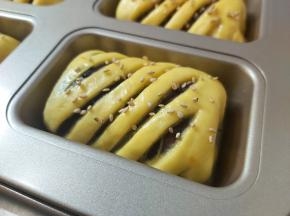 烤箱上火170度下火180度预热至少十分钟，同时，在发酵好的面团表面刷上一层薄薄的蛋液，撒上熟白芝麻。