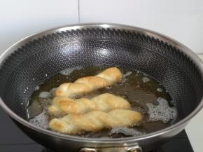 锅中加油中火烧热，待油温6成热时转中小火，再加入麻花，迅速用筷子翻动，“勤翻”，这样颜色均匀，我喜欢火大一点的更香酥，火候可以根据自己喜欢掌握，炸熟就可以。(建议一次不要放太多，不然不均匀）