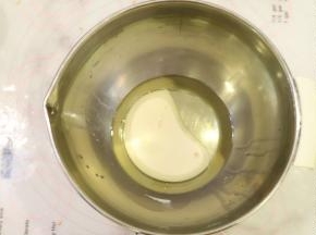 玉米油和牛奶用手动打蛋器混合乳化。