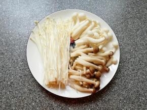 准备好食材，金针菇、白玉菇和蟹味菇切去根部清洗干净。
