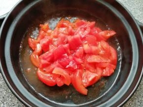 砂锅底部刷上一层食用油，下入西红柿翻炒至出汁。
