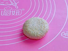 放手心里轻轻团一下，使芝麻黏紧，再掌心轻轻压扁。