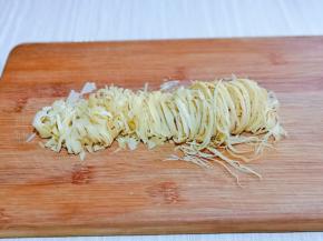 薄干豆腐皮冷水冲洗，再切丝。