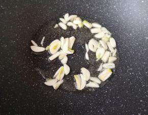 炒锅内倒适量的食用油烧热，下入蒜片炒香。