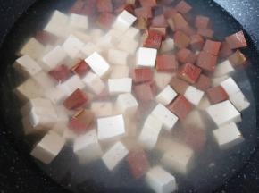 锅内放水加入1勺盐搅拌均匀，下入嫩豆腐和鸭血烧开，煮一分钟关火，捞出沥一下水备用。