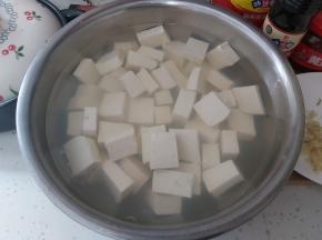 豆腐用冷盐水浸泡至少半小时，豆腐用冷盐水浸泡，在烹饪时不容易散掉，并且会保持豆腐的滑嫩，还可以有效的去除豆腥味。