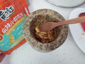 把麻辣小虾花生用蒜臼子捣碎。