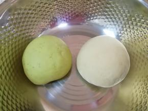 高筋面粉里面分次加入菠菜汁和成绿色的面团，加入温水和盐和成白色的面团，两个面团分别揉光，盖上保鲜膜饧发半个小时。