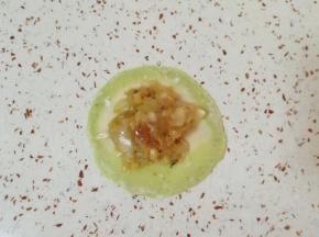 取一个擀好的饺子皮放上馅。