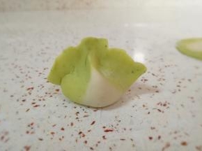 把饺子边缘捏上，然后用两个手的食指和大拇指一起挤捏一下，一个白菜饺子就包好了，有没有很像白菜呢？