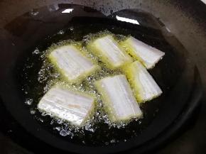 炒锅烧热倒入菜籽油，油烧至八成热下入带鱼段，带鱼下入油锅以后不要立即翻动，过一会儿用筷子轻轻推一下，很容易推动就可以翻面了。