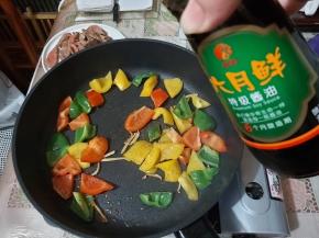 倒入彩椒以及六月鲜特级酱油，大火炒匀。
