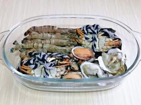 把花蛤摆在蒸盘下面，再摆上大闸蟹，黑虎虾，鲍鱼，生蚝。
