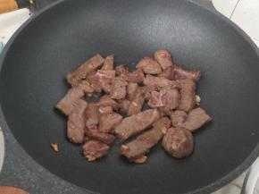 把腌渍好的牛肉倒入锅内，大火翻炒均匀。