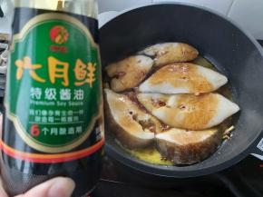 在比目鱼表面淋上少许的六月鲜特级酱油。