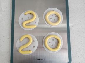 黄色面团分别取4个20克的面团，搓成长条，摆成2020这4个数字