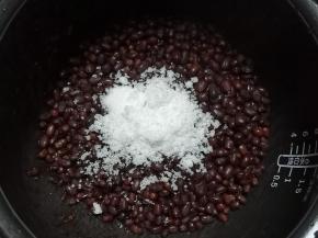 倒入白砂糖，不要用筷子搅拌，两手拿起锅来掂几下就可以了，这样可以避免将红豆搅烂，做好的红豆放容器中密封，冰箱冷藏糖渍一晚就可以了