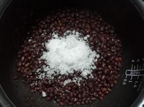倒入白砂糖，不要用筷子搅拌，两手拿起锅来掂几下就可以了，这样可以避免将红豆搅烂，做好的红豆放容器中密封，冰箱冷藏糖渍一晚就可以了