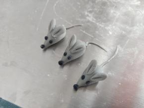 黑色面团做眼睛和鼻子，再用剩余的灰色面团搓3条尾巴，分别粘好